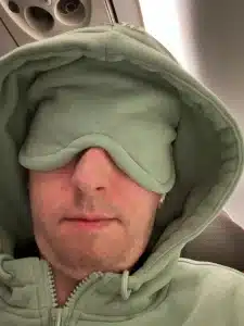 wearing a Comfrt Airplane Zip Hoodie with eye shades