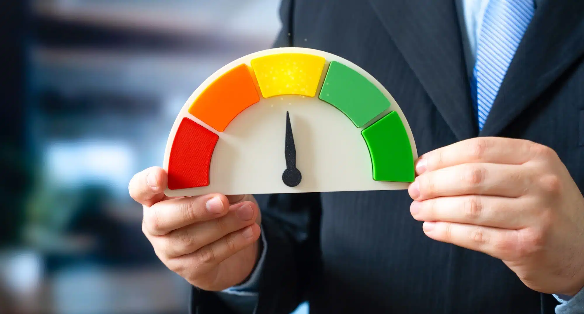 holding a guage with a needle pointing to a yellow section