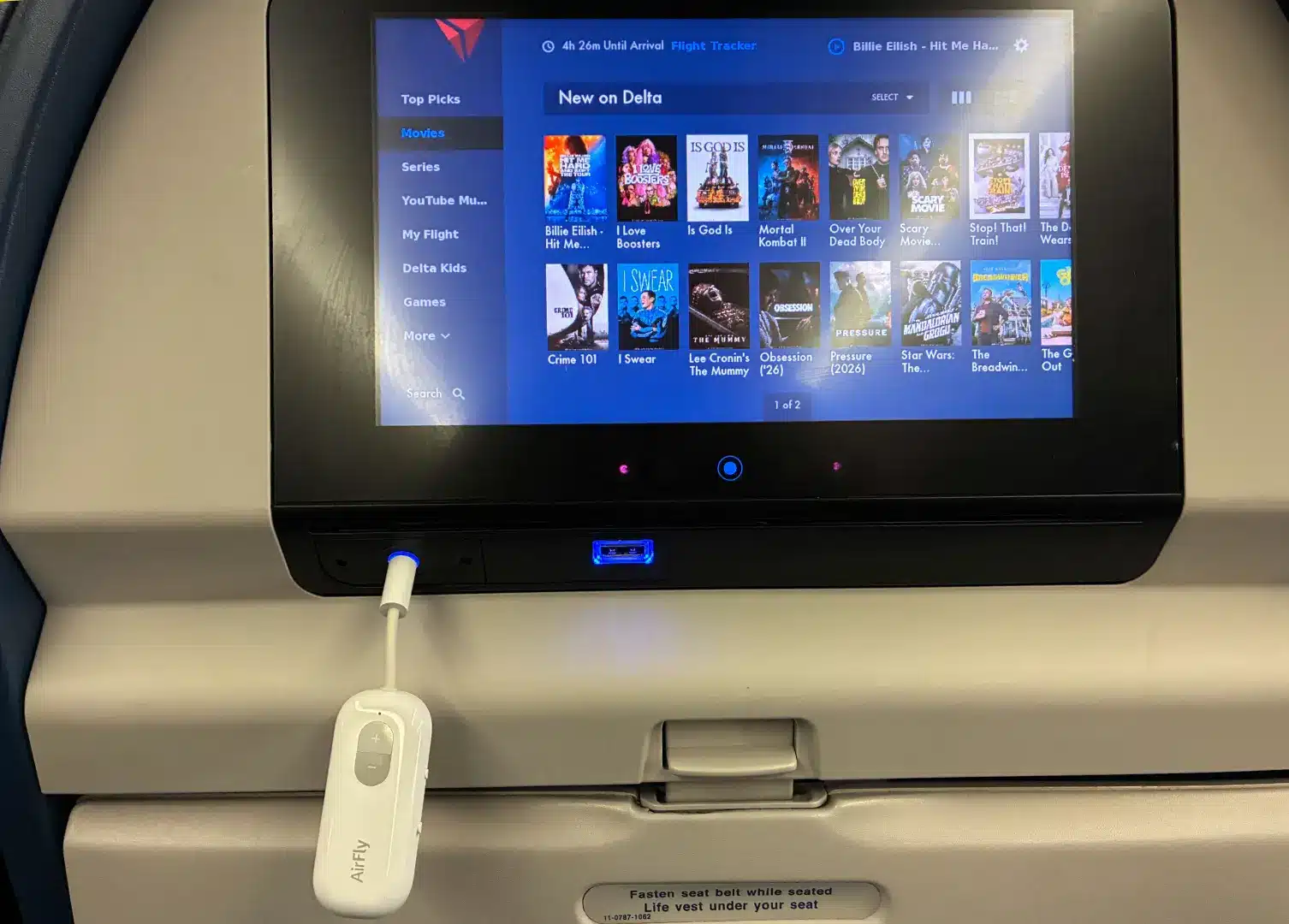 Twelve South AirFly SE next to a media screen on a plane