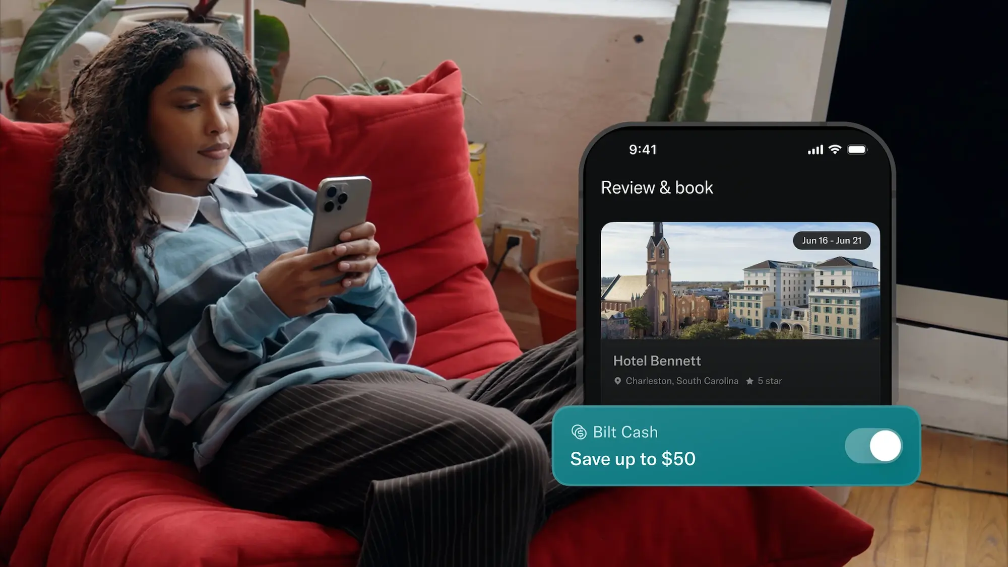 young woman lying on a coach with the Bilt app open on her phone